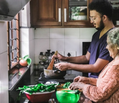 Son helping mother prepare a meal in a kitchen