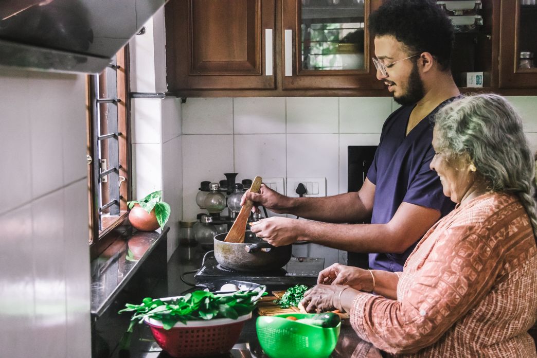 Son helping mother prepare a meal in a kitchen