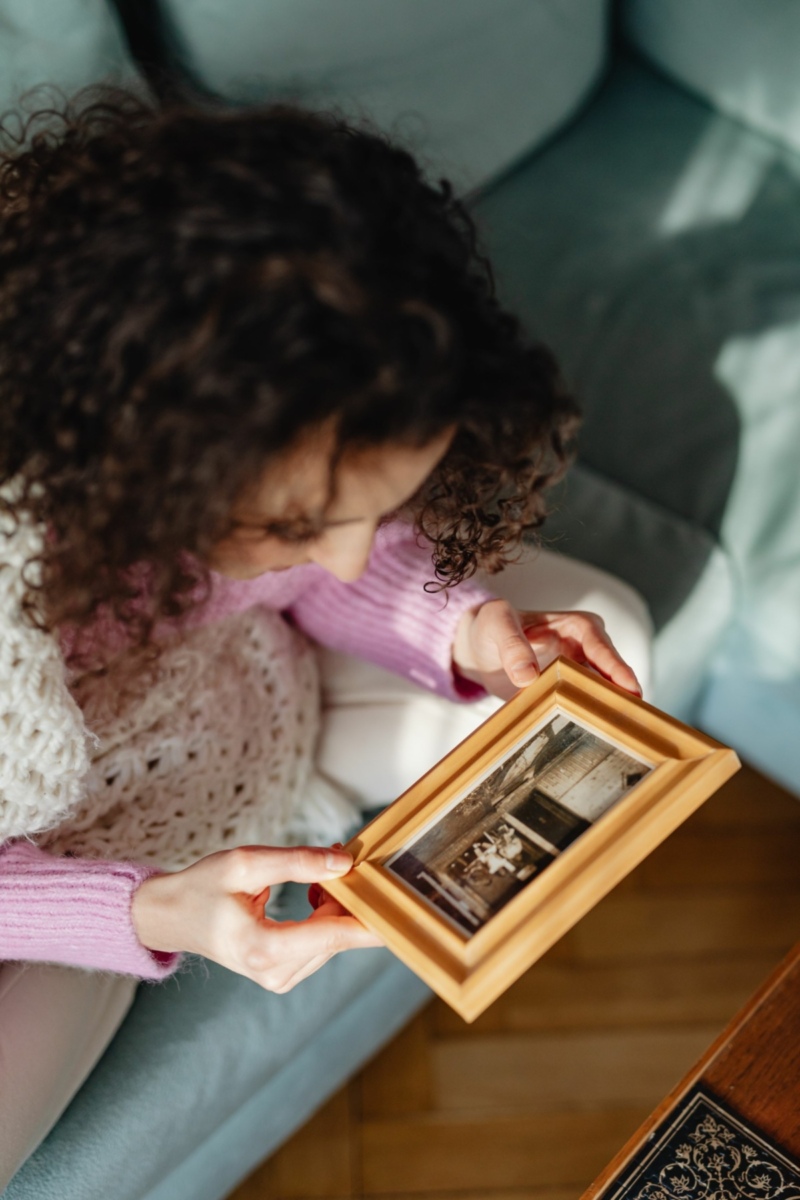 Young Woman Looking at Framed Photograph