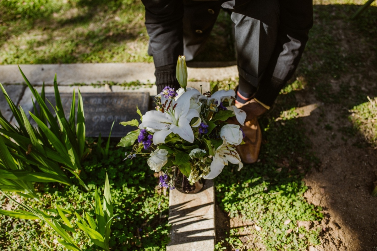 Person placing flowers on grave