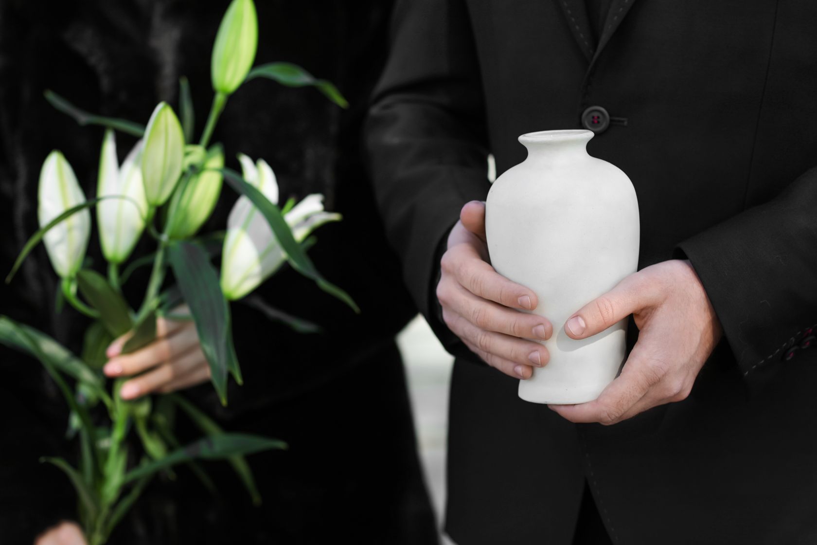 Man holding urn at funeral in New Zealand
