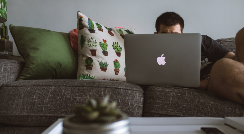 Man sat on sofa with laptop
