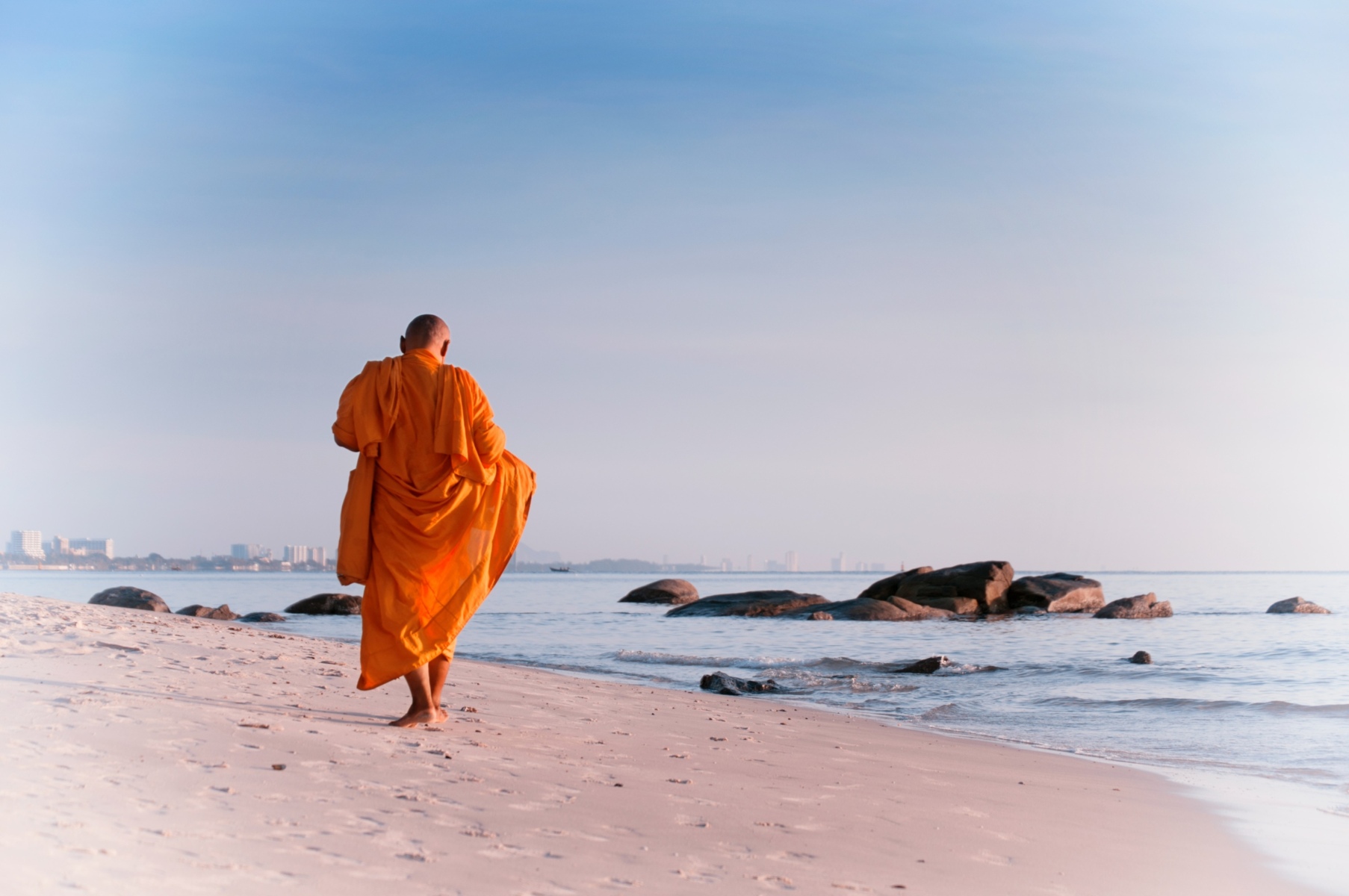 Buddhist Monk walking on the beach