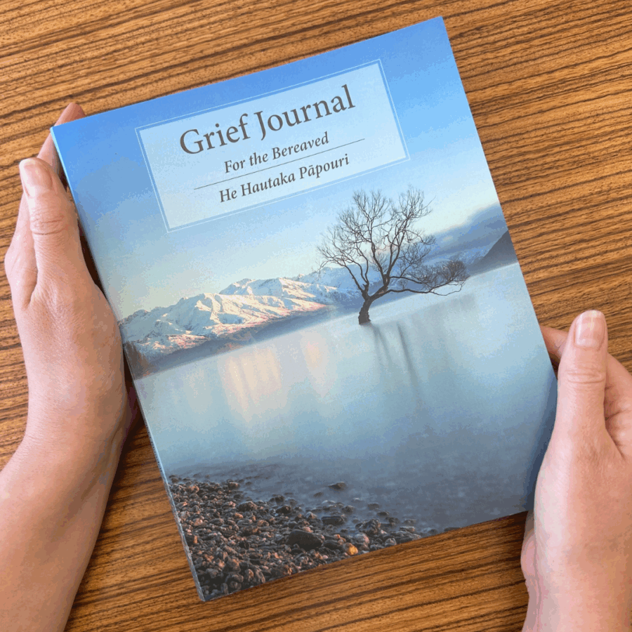 A woman's hands hold the Grief Journal