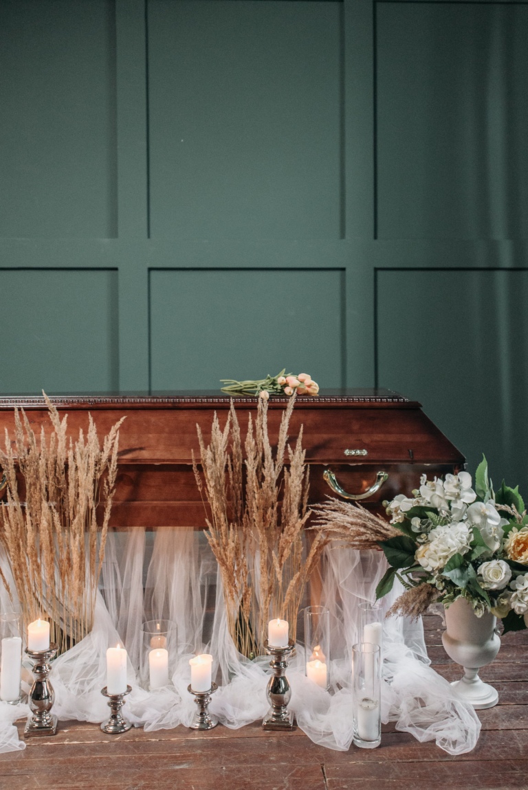 Coffin in room with candles and flowers